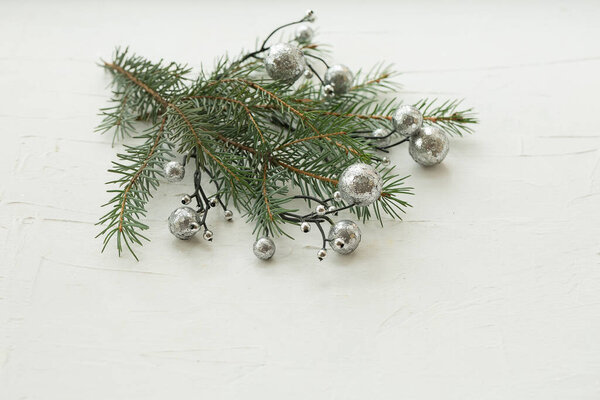 Christmas tree branches and decorations on a white textured horizontal background. Christmas composition. Layout, copy space. Selective focus.