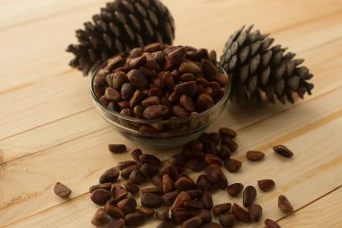 Ahşap bir arka planda çam fıstığı kabuğu soyulmamış. Sağlık için yararlı bir ürün.