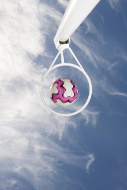 Netball Passing through a netball hoop against a blue sky clipart