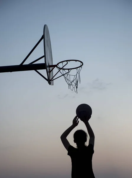 Silhouette Basketball Player shooting a basketball at a hoop