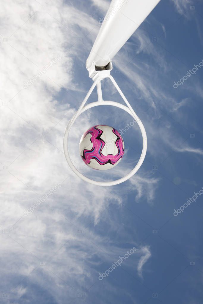 Netball Passing through a netball hoop against a blue sky