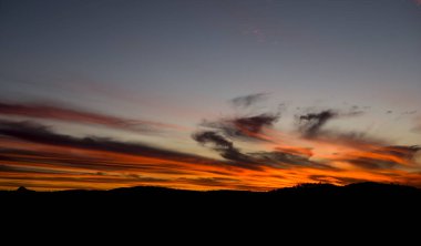 Günbatımı turuncu ve mavi gökyüzü ile kontrast Dağları üzerinde