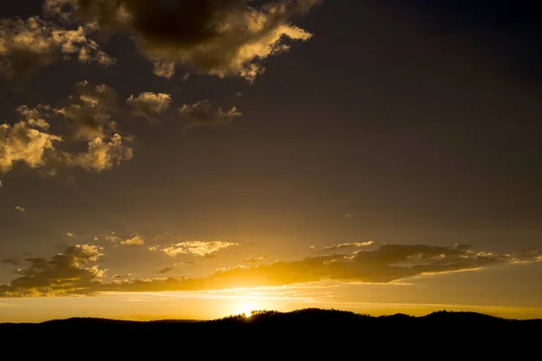 Günbatımı ile sarı bir gökyüzü kontrast Dağları üzerinde