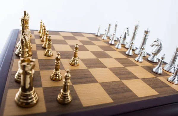 Ahşap satranç tahtasının altın ve gümüş satranç taşları