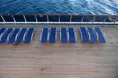 Şezlong okyanusun içinde belgili tanımlık geçmiş bir gemi güverte üzerinde.