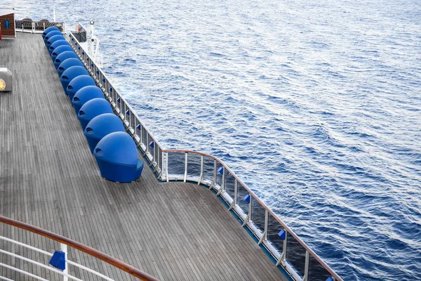 Şezlong okyanusun içinde belgili tanımlık geçmiş bir gemi güverte üzerinde.