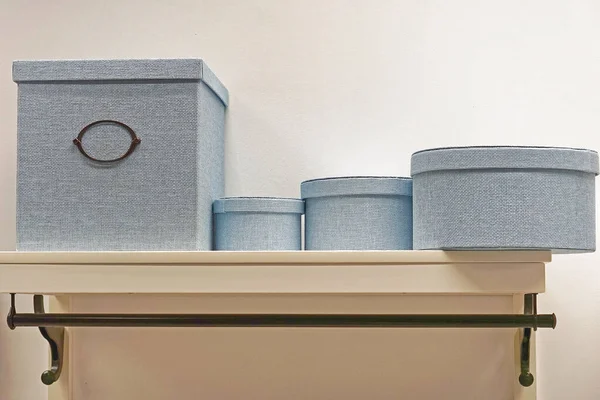 Decorative storage boxes at shelf in home