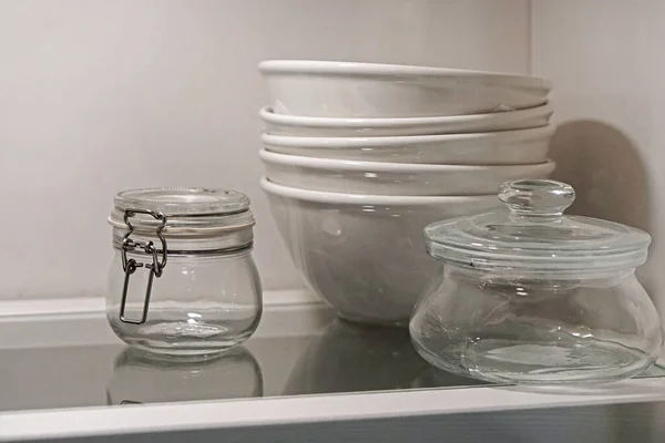 Bowls and jars dishes at glass shelf