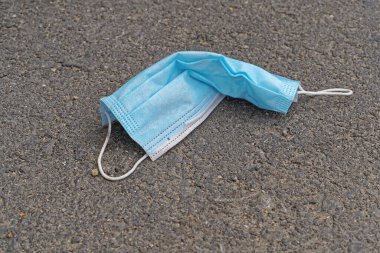 Beton kaldırımda reddedilmiş tıbbi maske