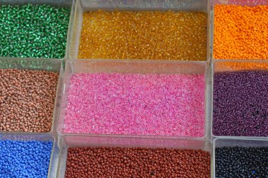 Renkli plastik boncuklar tepsilerde zanaat malzemesi