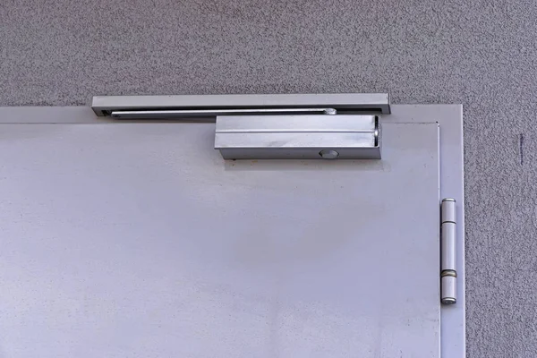 Automatic closer device at top of door