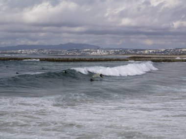 Bir grup insan dalgalar üzerinde 10 Ekim ayında Costa da Caparica, Portekiz / alıcı.