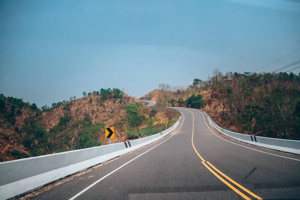 Tayland'da dağ yolu. bulutlar ve yaz aylarında güzel asfalt yol ile güneşli gökyüzü. Vintage tonlama. Seyahat arka plan, Peyzaj, Ulaşım