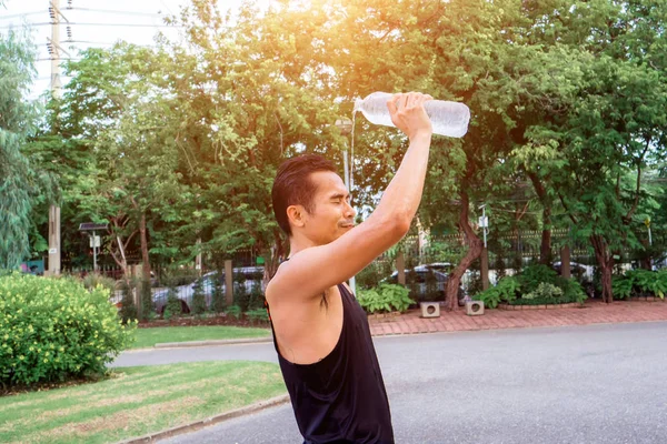 Hombre atleta asiático macho enfriamiento por verter agua en la parte superior de Fotos De Stock