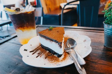 Koyu çikolatalı kek, fırın yok ve sade kahve, limonlu buz.