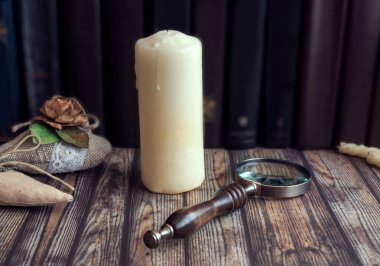 Tema edebiyat, mum, eski kitaplar arka plan üzerinde büyüteç