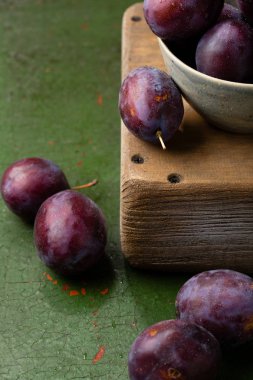 Ahşap arka plan üzerinde olgunlaşmış mavi Erik