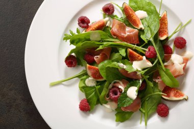 Prosciutto plaka üzerinde taze salata