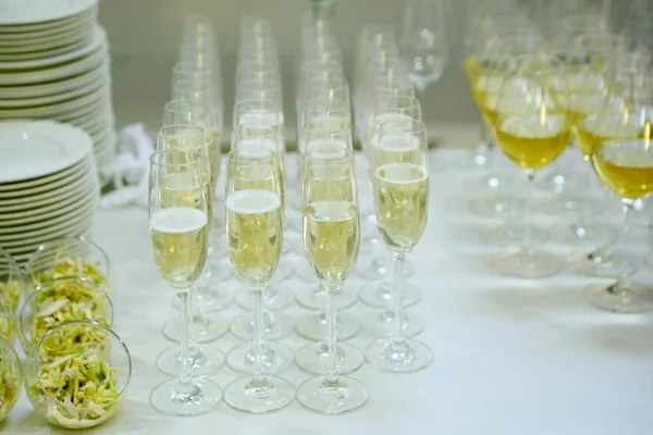 Glasses of drinks in a row on white table