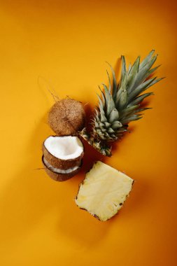 Ananas ve hindistancevizi sarı zemin üzerine dilimlenmiş