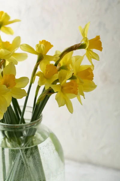 Gele bloemen in glazen pot op wit — Stockfoto