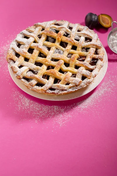 Plum pie on pink backdrop — Stock Photo, Image