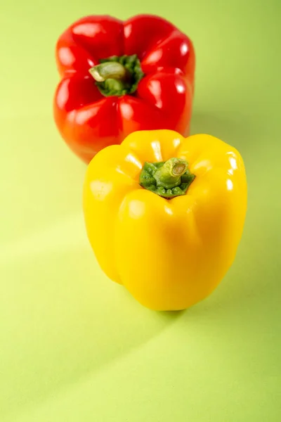 Yellow and red paprika on green background — 스톡 사진