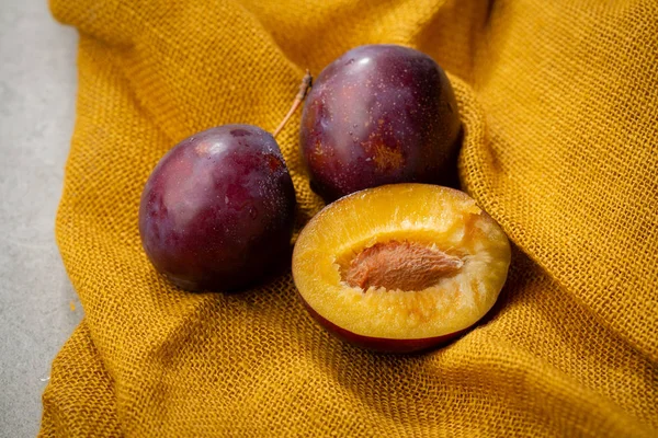 Ciruelas frescas ecológicas sobre fondo amarillo — Foto de Stock