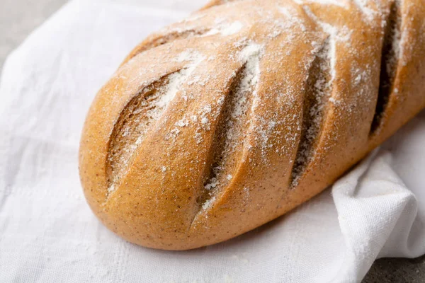 Una barra de pan sobre tela blanca — Foto de Stock