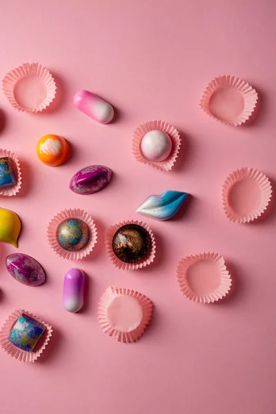 Roze achtergrond met chocolade bombons boven — Stockfoto