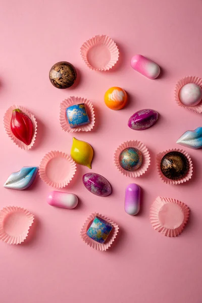 Dulces bombones de chocolate de lujo desde arriba en rosa —  Fotos de Stock