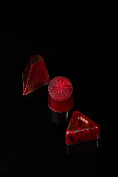 Червоні шоколадні бони на чорному фоні — стокове фото
