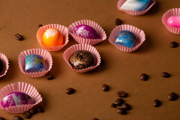 Çikolata bonbon ve kahve çekirdekleri ile renkli arka plan — Stok fotoğraf