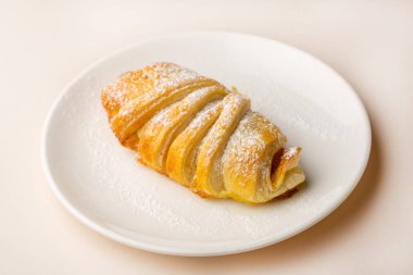 Beyaz plaka üzerinde taze pişmiş kruvasan