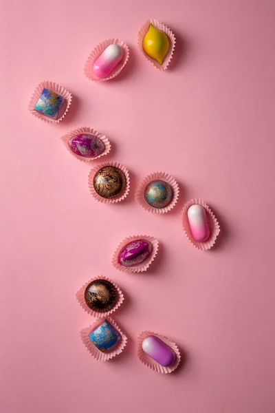 chocolate bonbons set background top view on pink