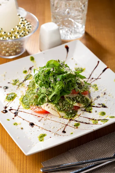 Salada Caprese com molho pesto close-up no prato — Fotografia de Stock