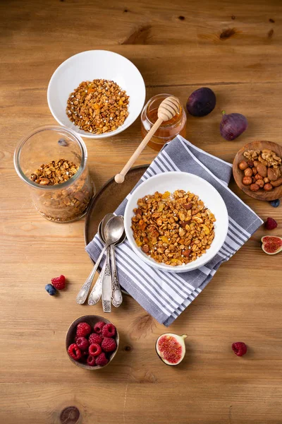 Granola in ciotole e barattolo sul tavolo di legno — Foto Stock