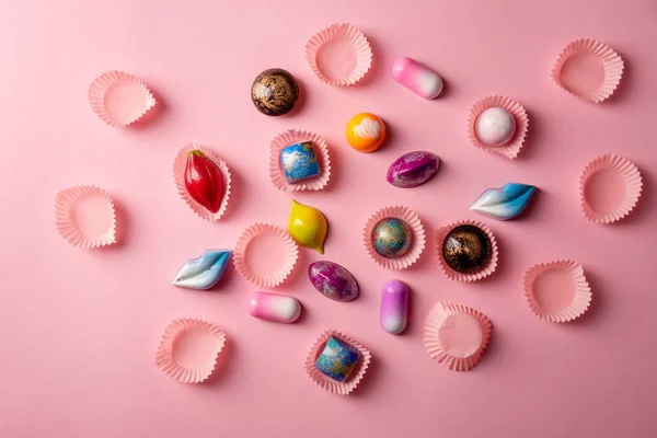Pink food background with chocolate bonbons collection