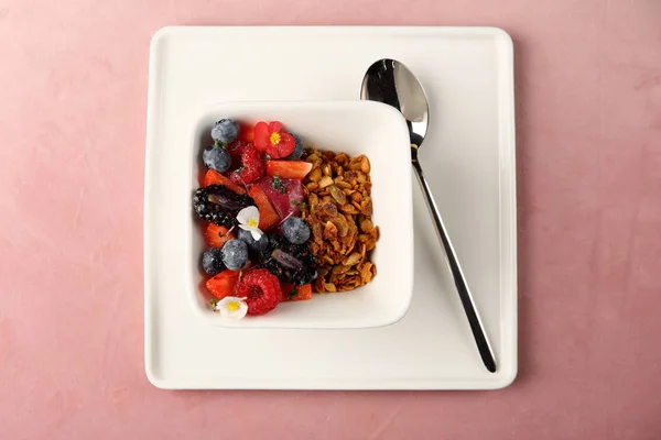 Granola with berry on pink background, healthy breakfast — Stock Photo, Image