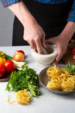 Erkekler mutfakta makarna için sos pişiriyor, yemek yapıyor.