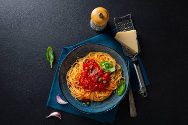 Siyah tahta üzerine kırmızı domates soslu spagetti.