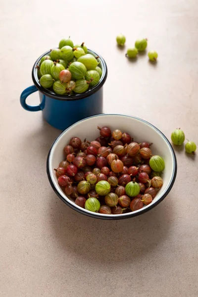 碗中和杯子中新鲜的红色和绿色醋栗 — 图库照片