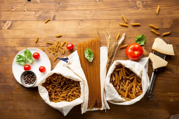 Bovenaanzicht Van Volkoren Tarwepasta Set Katoenen Opbergzak Houten Tafel — Stockfoto