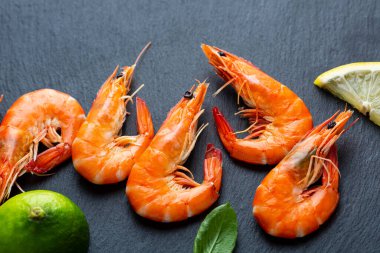 Siyah yüzeye limonlu kaplan karideslerini yakın.