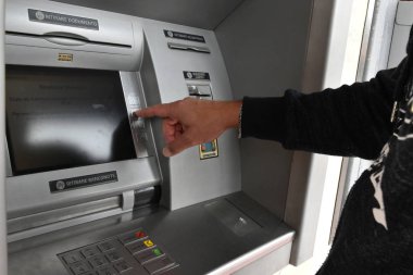 Bir adam para makinesine para taşırken