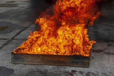 Su ile bir metal kutu içinde yanan bir alev.