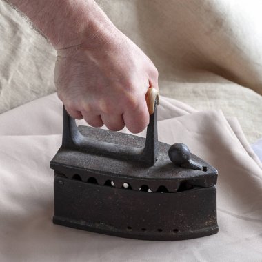 Bir adamın elinde eski Ütü demir.