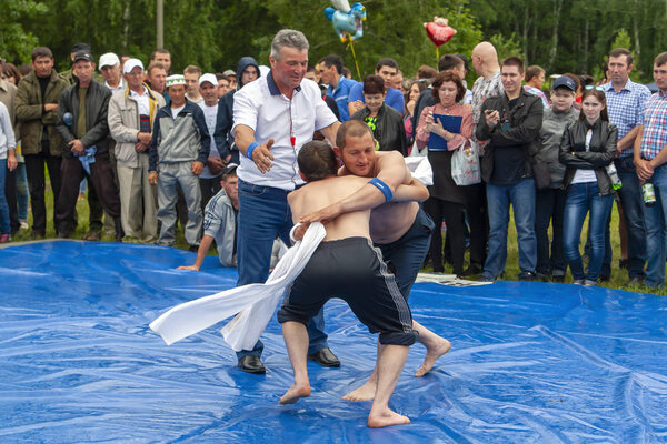 Ufa, Russia, July 8, 2017: the national wrestling kuresh at Sabantuy in the open field. Sabantuy is the annual national festival of the end of spring field work for the Tatars and Bashkirs. Free entrance, public.