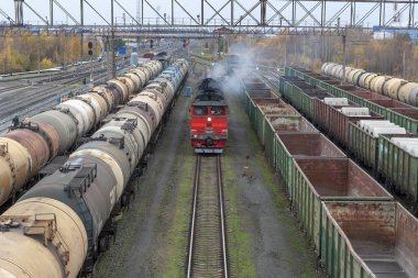 Surgut, Rusya Federasyonu. 10/04/2018. Surgut şehir tren istasyonu. Kırmızı lokomotif yaklaşıyor.