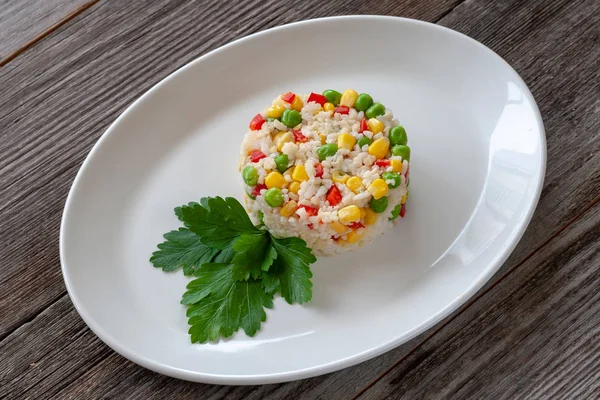 Vegetarian dish: a dish of boiled rice, corn, green peas and swe